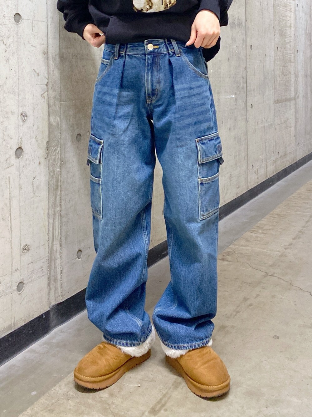 ブラック系のパーカー、ブルー系のカーゴパンツ、ブラック系のショルダーバッグを着用したレディースの冬コーディネートの6枚目の写真