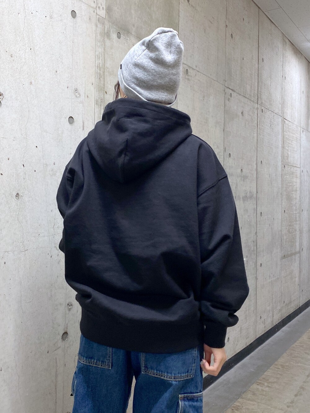 ブラック系のパーカー、ブルー系のカーゴパンツ、ブラック系のショルダーバッグを着用したレディースの冬コーディネートの5枚目の写真