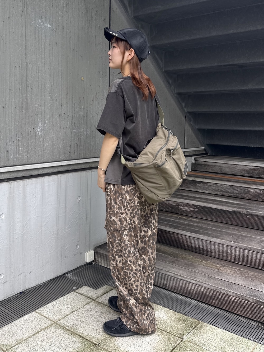 ブラック系のTシャツ/カットソー、ベージュ系のカーゴパンツ、グリーン系のショルダーバッグを着用したレディースの夏コーディネートの2枚目の写真