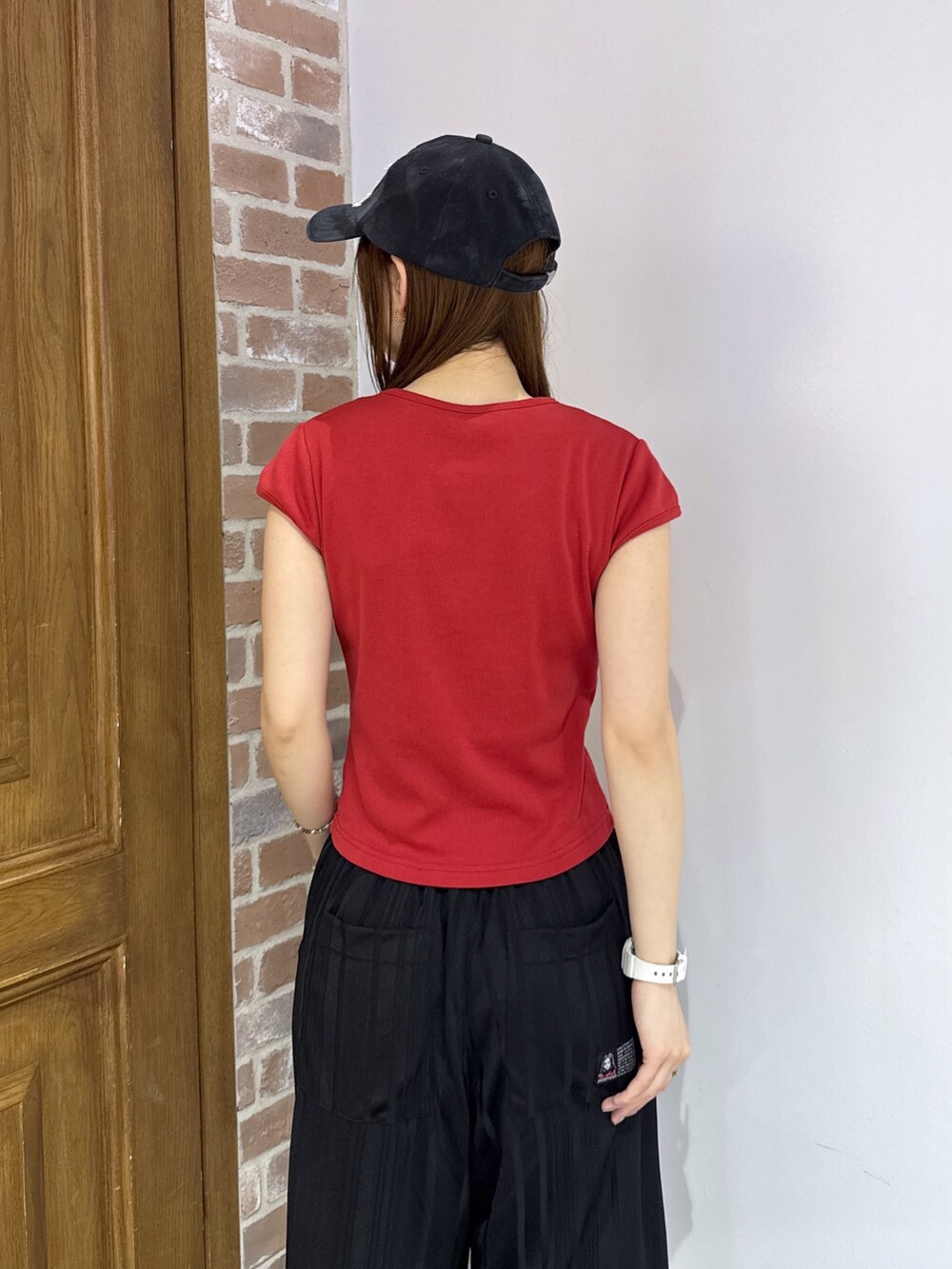 ブラック系のその他パンツ、ベージュ系のバックパック/リュック、レッド系のTシャツ/カットソーを着用したレディースの夏コーディネートの5枚目の写真