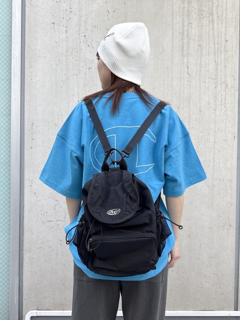 ブラック系のスウェットパンツ、ブルー系のTシャツ/カットソー、ブラック系のバックパック/リュックを着用したレディースの春コーディネートの7枚目の写真