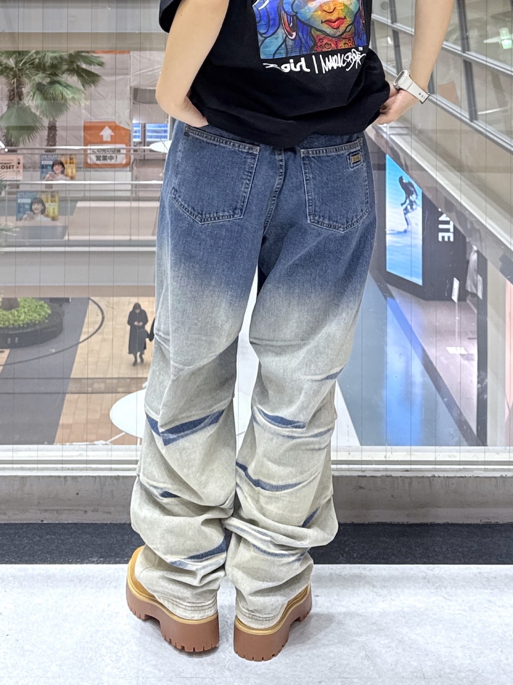 ブラック系のTシャツ/カットソー、グレー系のニット/セーター、ブルー系のデニムパンツを着用したレディースの冬コーディネートの9枚目の写真