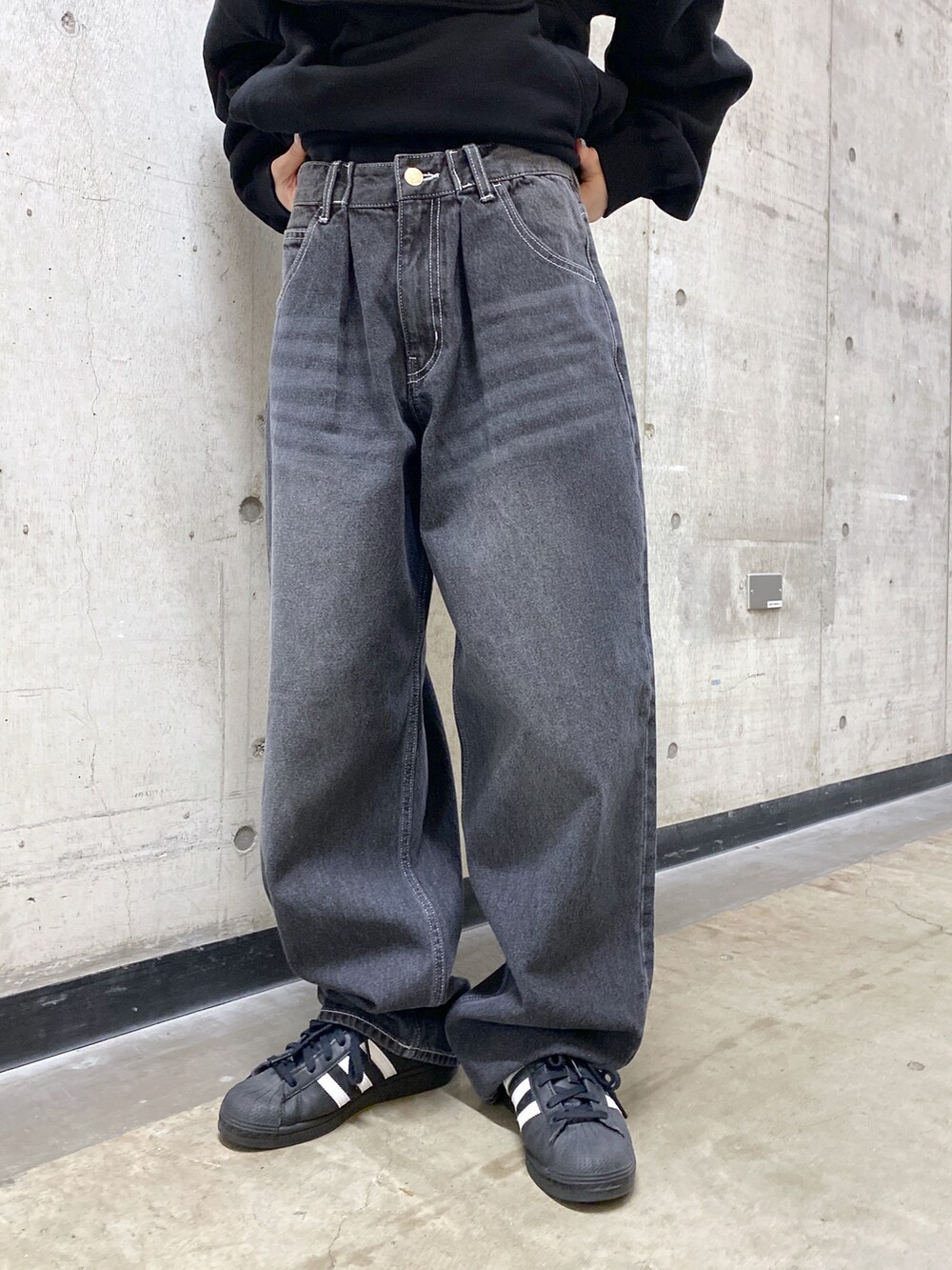 ブラック系のパーカー、ブラック系のデニムパンツ、グレー系のニットキャップ/ビーニーを着用したレディースの冬コーディネートの5枚目の写真