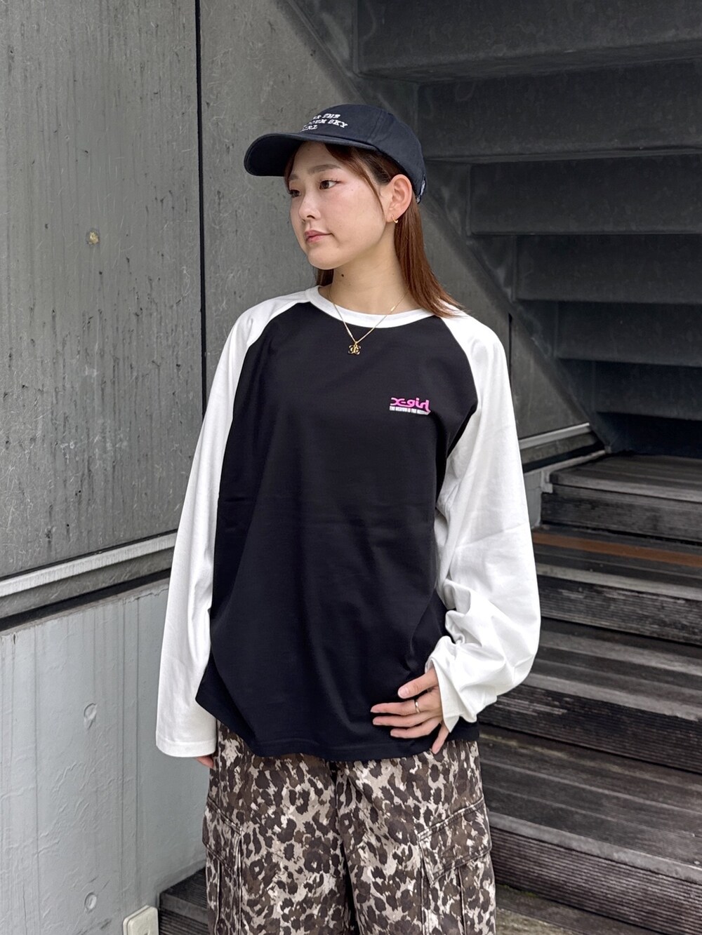 ブラック系のTシャツ/カットソー、ベージュ系のカーゴパンツ、ブラック系のキャップを着用したレディースの秋コーディネートの4枚目の写真