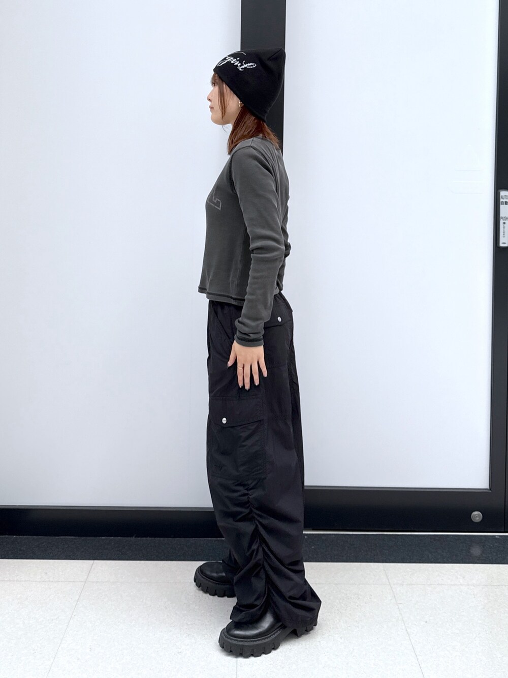 ブラック系のカーゴパンツ、ゴールド系のハンドバッグ、ブラック系のTシャツ/カットソーを着用したレディースの秋コーディネートの8枚目の写真