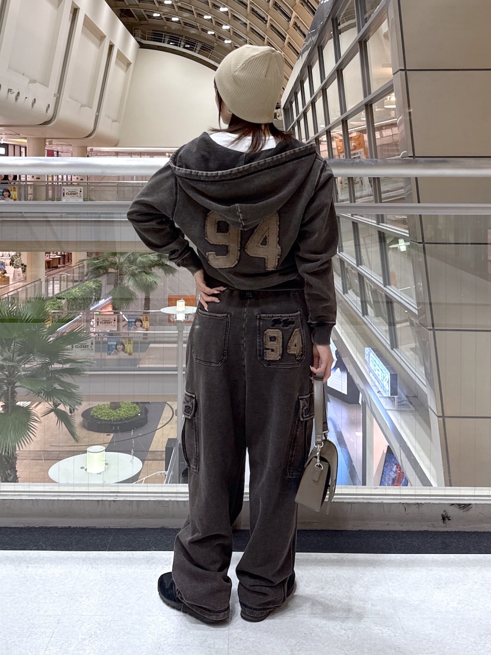 ブラック系のパーカー、ブラック系のスウェットパンツ、ホワイト系のTシャツ/カットソーを着用したレディースの冬コーディネートの3枚目の写真