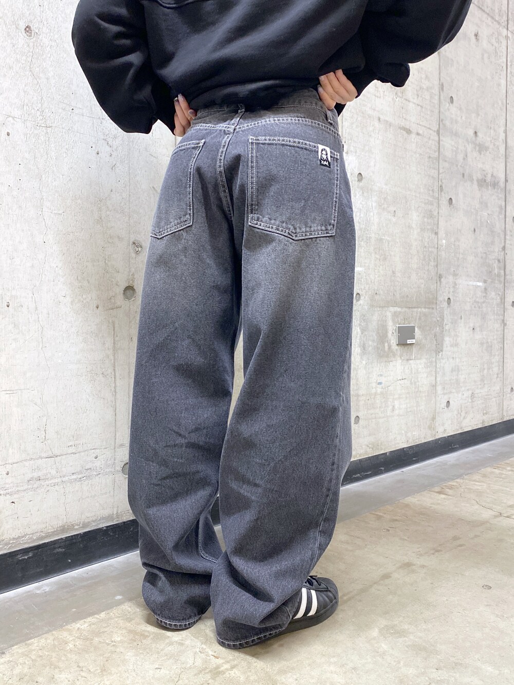 ブラック系のパーカー、ブラック系のデニムパンツ、グレー系のニットキャップ/ビーニーを着用したレディースの冬コーディネートの7枚目の写真