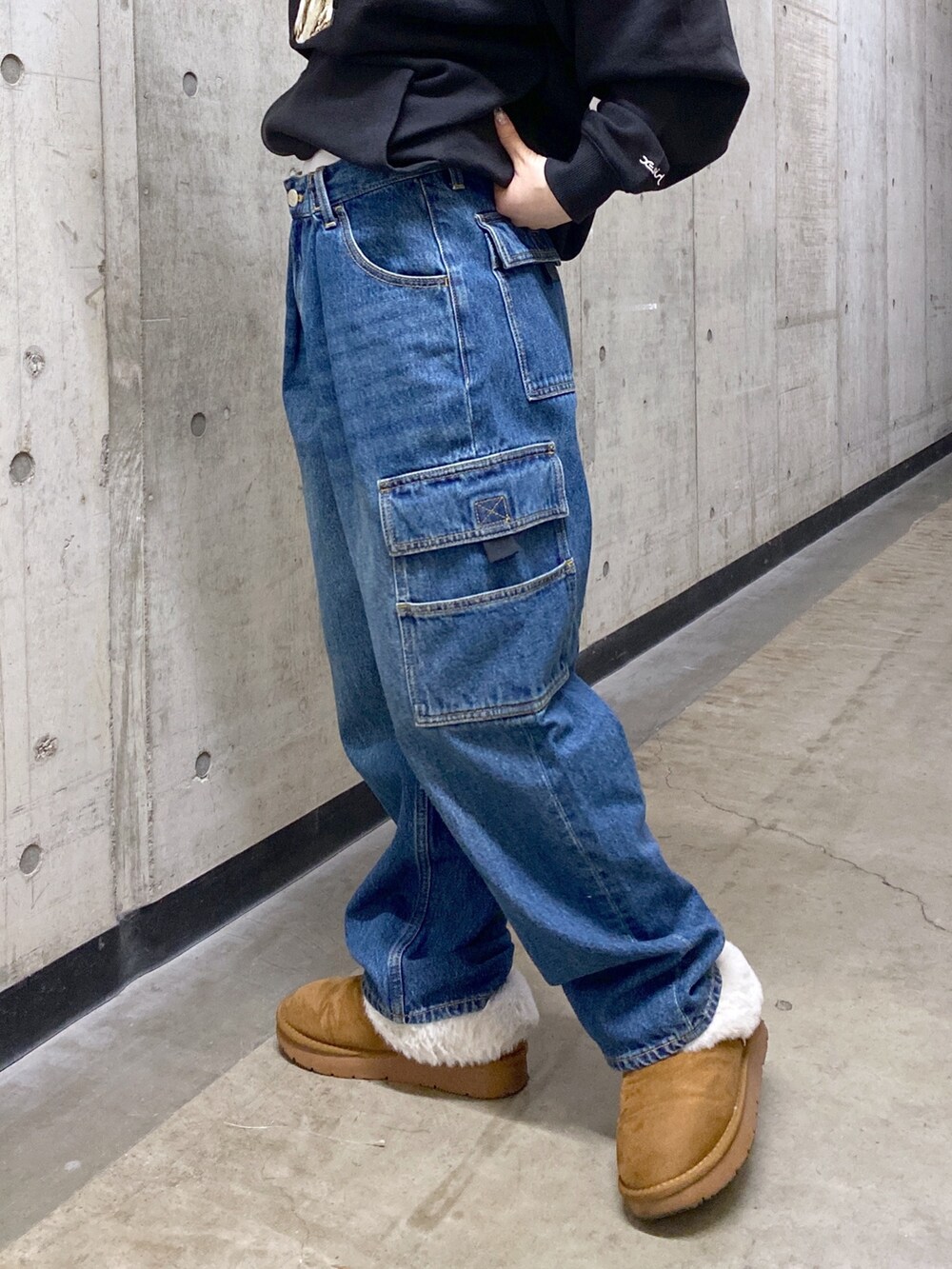 ブラック系のパーカー、ブルー系のカーゴパンツ、ブラック系のショルダーバッグを着用したレディースの冬コーディネートの7枚目の写真