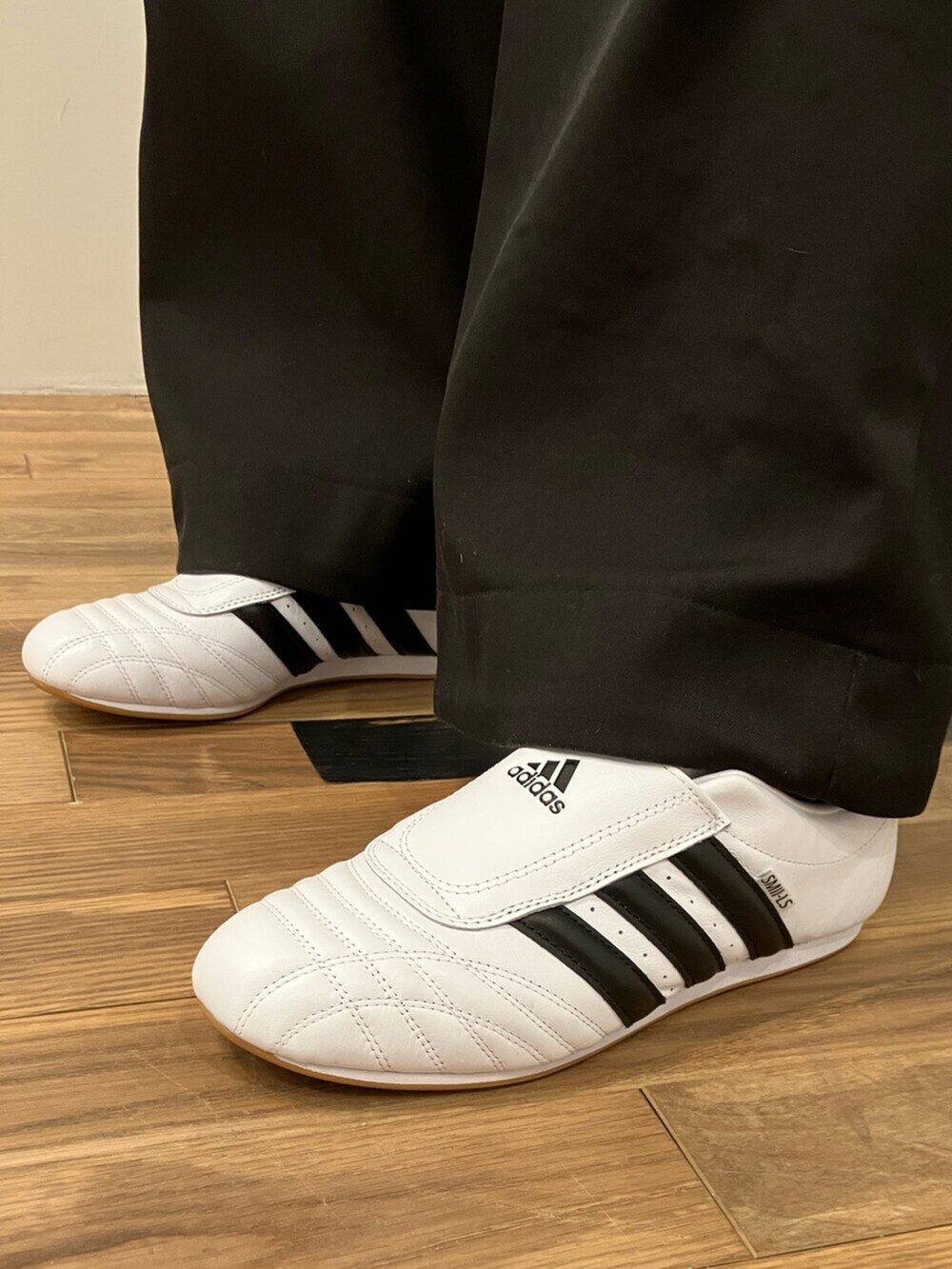 ブラック系のナイロンジャケット、ホワイト系のシューズ、シルバー系のショルダーバッグを着用したメンズの冬コーディネートの2枚目の写真