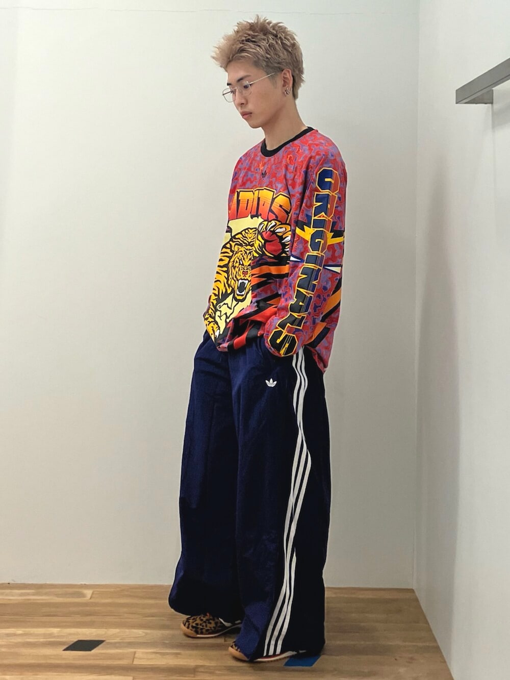 レッド系のTシャツ/カットソー、ブルー系のスウェットパンツ、ブラウン系のスニーカーを着用したメンズの冬コーディネートの2枚目の写真