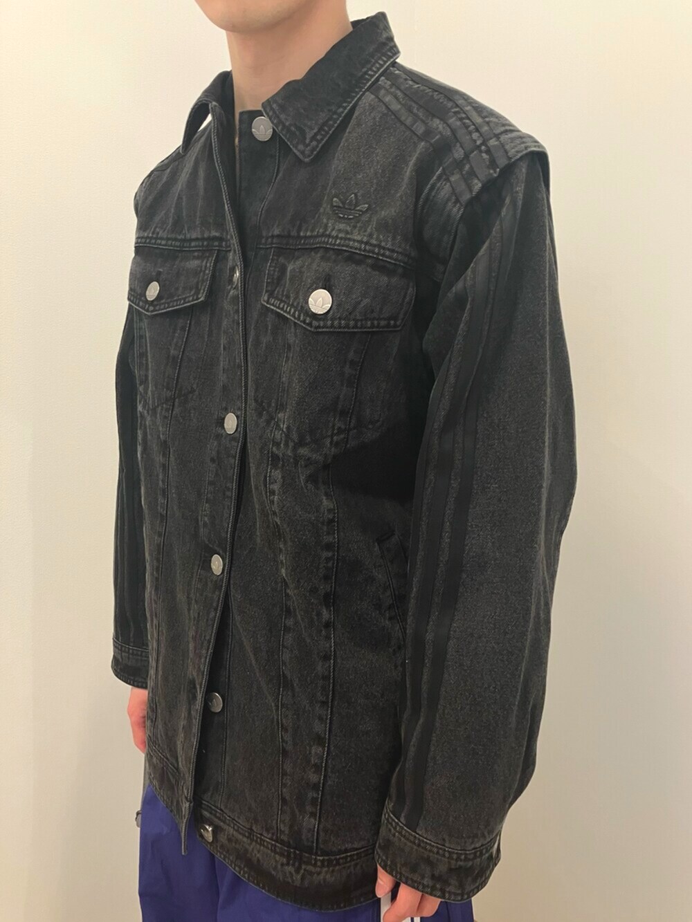 ブラック系のスニーカー、ブルー系のスウェットパンツ、ブラック系のデニムジャケットを着用したメンズの冬コーディネートの2枚目の写真