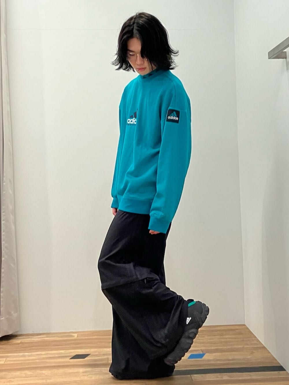 ブラック系のその他パンツ、ブラック系のシューズ、グリーン系のトップスを着用したメンズの春コーディネートの2枚目の写真