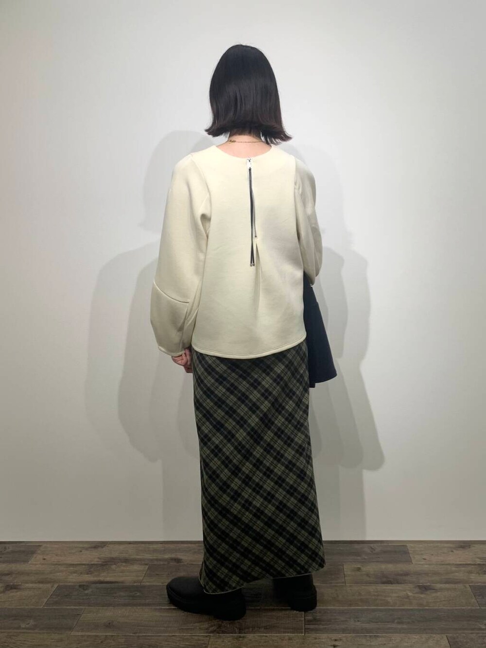 ブルー系のステンカラーコート、ブラック系のブーツ、ホワイト系のTシャツ/カットソーを着用したレディースの秋コーディネートの8枚目の写真