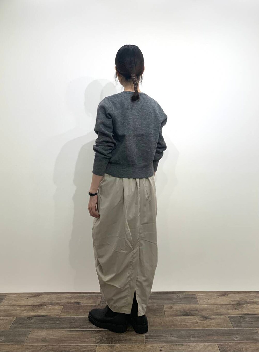 ブラック系のブーツ、ベージュ系のスカート、グレー系のカーディガン/ボレロを着用したレディースの秋コーディネートの4枚目の写真