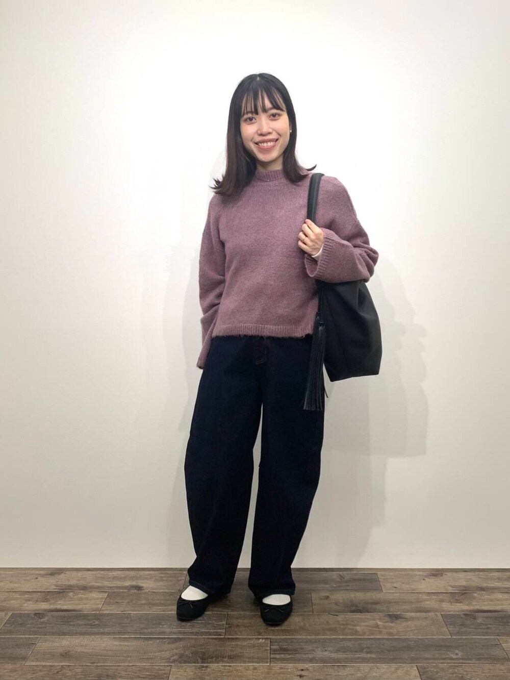 ブラック系のブーツ、ブルー系のデニムパンツ、ブラック系のトートバッグを着用したレディースの秋コーディネートの3枚目の写真