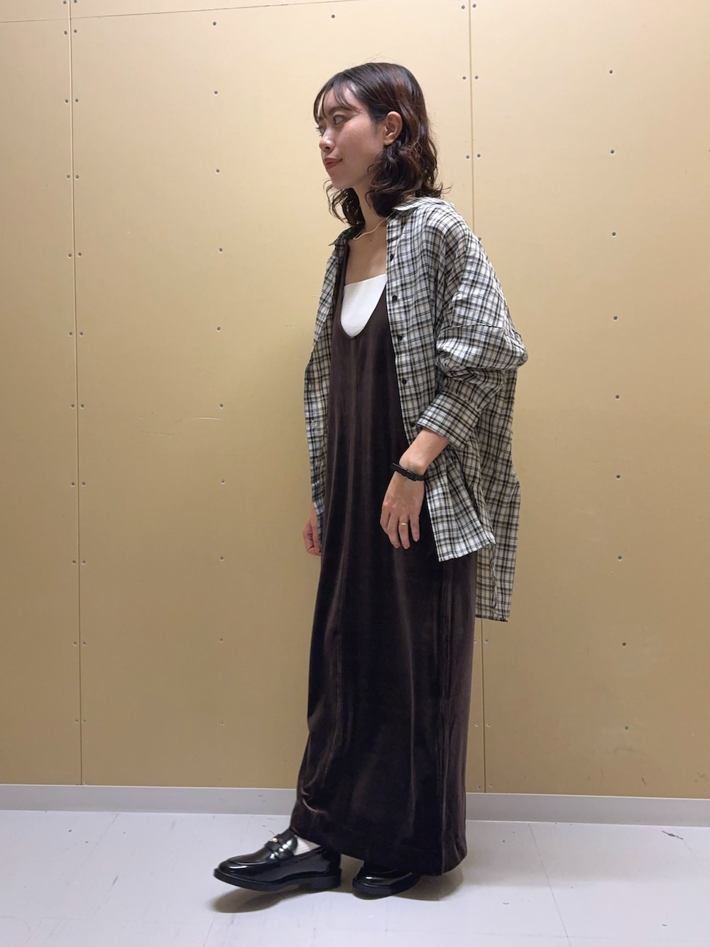 ブラウン系のワンピース、ホワイト系のシャツ/ブラウス、ブラック系のローファーを着用したレディースの秋コーディネートの2枚目の写真