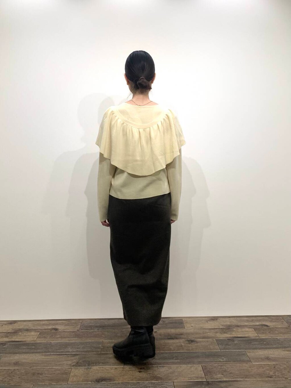 ブラック系のブーツ、ホワイト系のニット/セーター、ブラウン系のスカートを着用したレディースの秋コーディネートの4枚目の写真