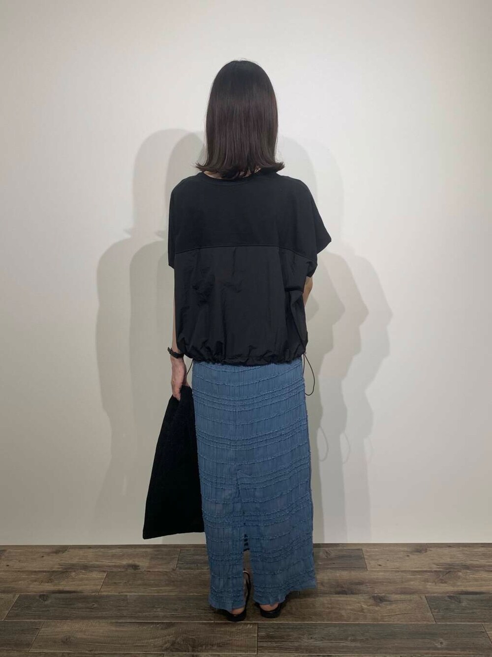 ブラック系のサンダル、ブルー系のスカート、ブラック系のトートバッグを着用したレディースの夏コーディネートの5枚目の写真