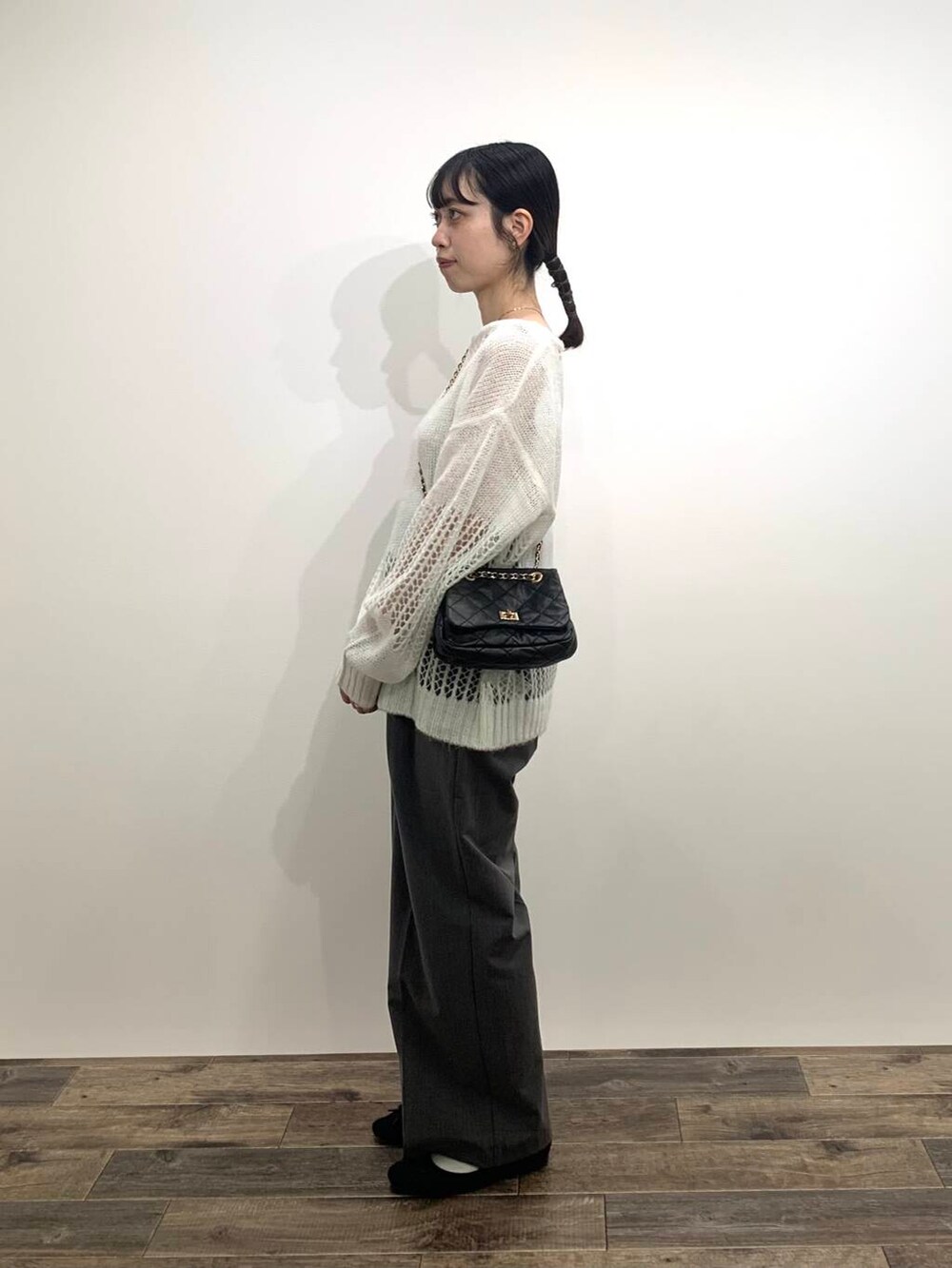 グレー系のその他パンツ、ブラック系のショルダーバッグ、ホワイト系のニット/セーターを着用したレディースの秋コーディネートの3枚目の写真