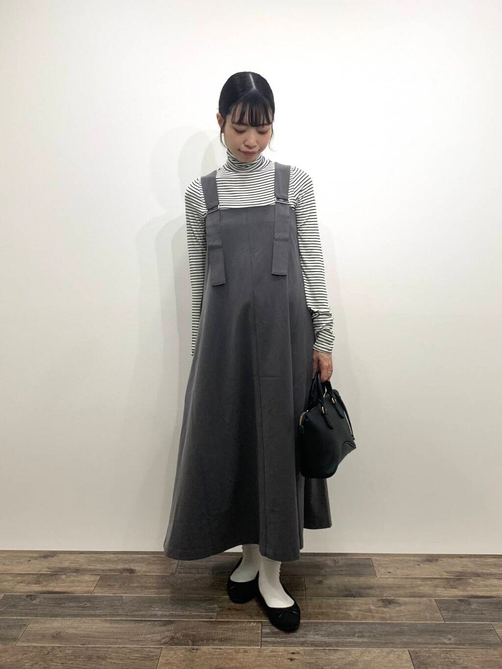 ブラック系のボストンバッグ、グレー系のワンピース、ホワイト系のTシャツ/カットソーを着用したレディースの秋コーディネートの3枚目の写真