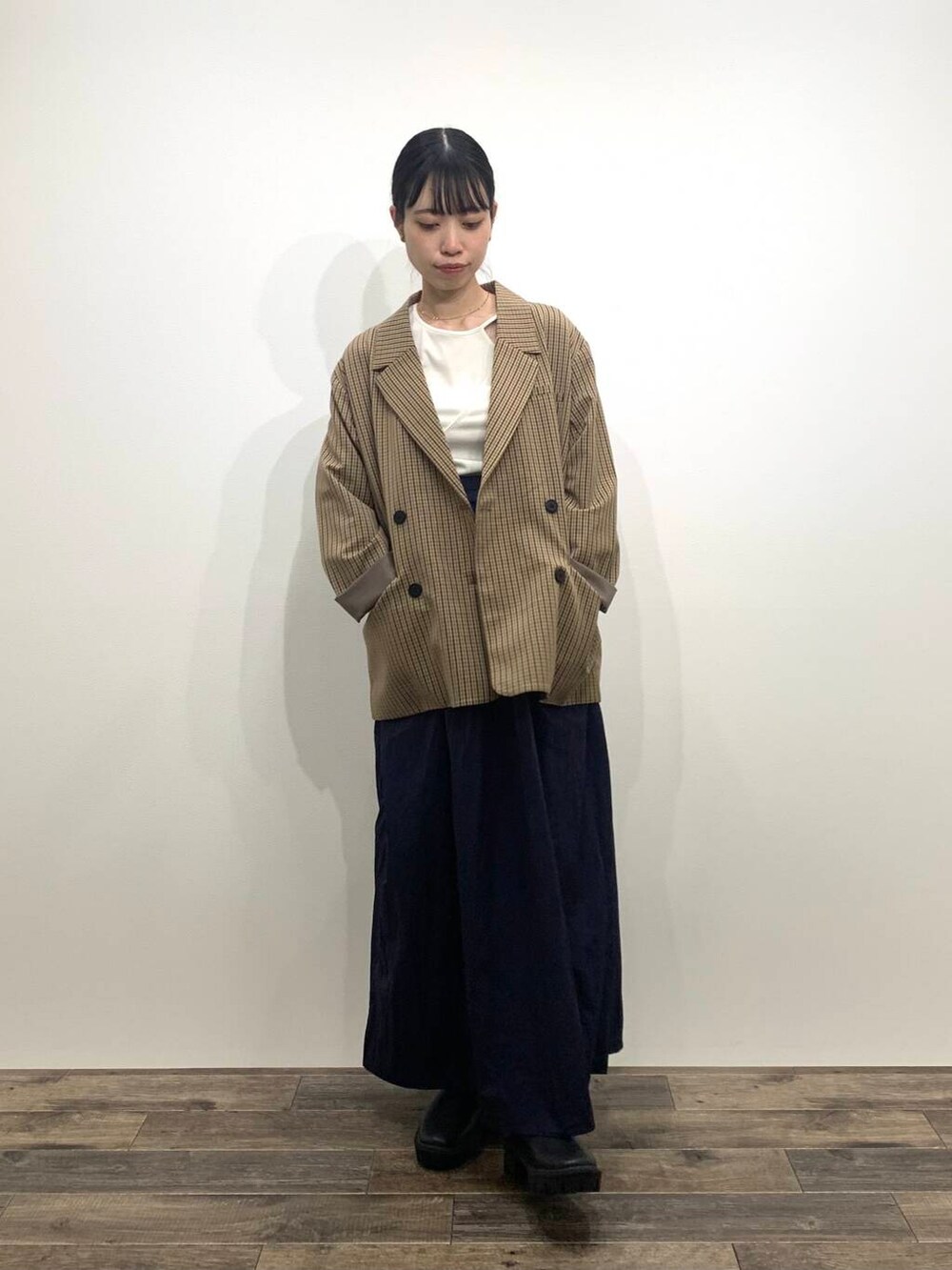 ブラック系のブーツ、ブルー系のスカート、ブラウン系のテーラードジャケットを着用したレディースの秋コーディネートの3枚目の写真