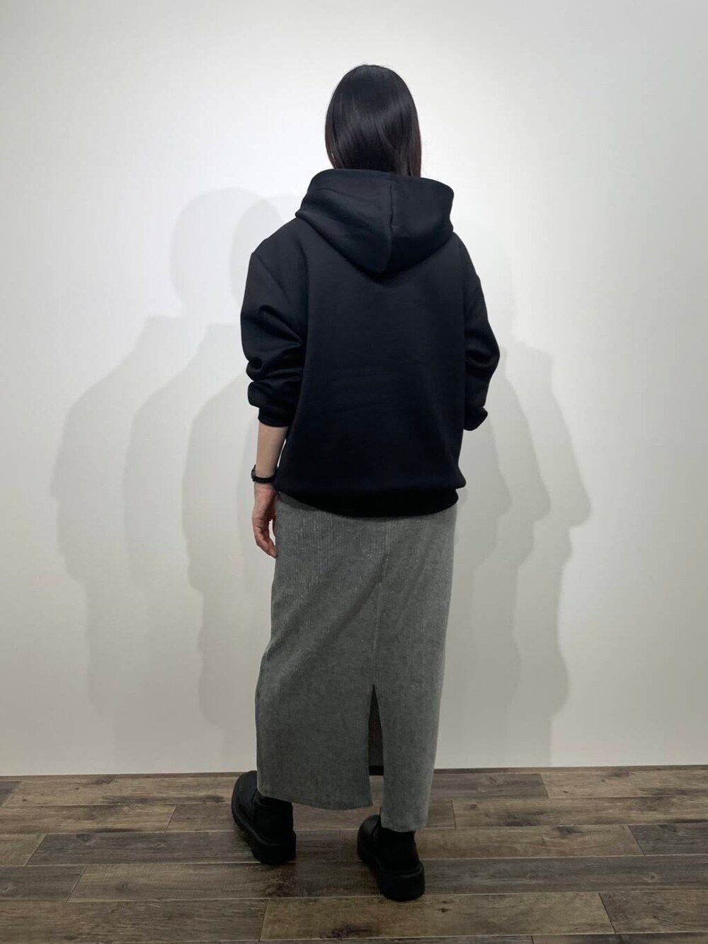 ブラック系のパーカー、グレー系のスカートを着用したレディースの秋コーディネートの4枚目の写真