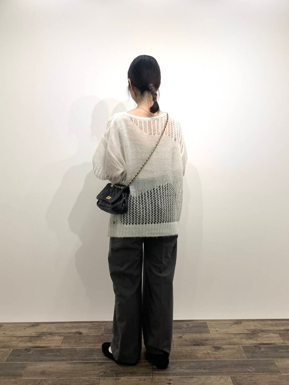 グレー系のその他パンツ、ブラック系のショルダーバッグ、ホワイト系のニット/セーターを着用したレディースの秋コーディネートの4枚目の写真