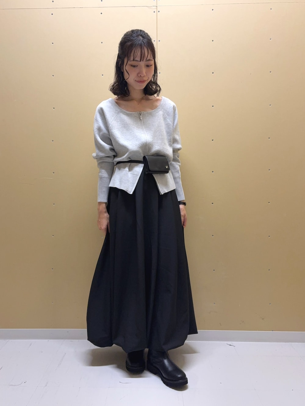 ブラック系のスカート、ブラック系のブーツ、グレー系のニット/セーターを着用したレディースの秋コーディネートの3枚目の写真