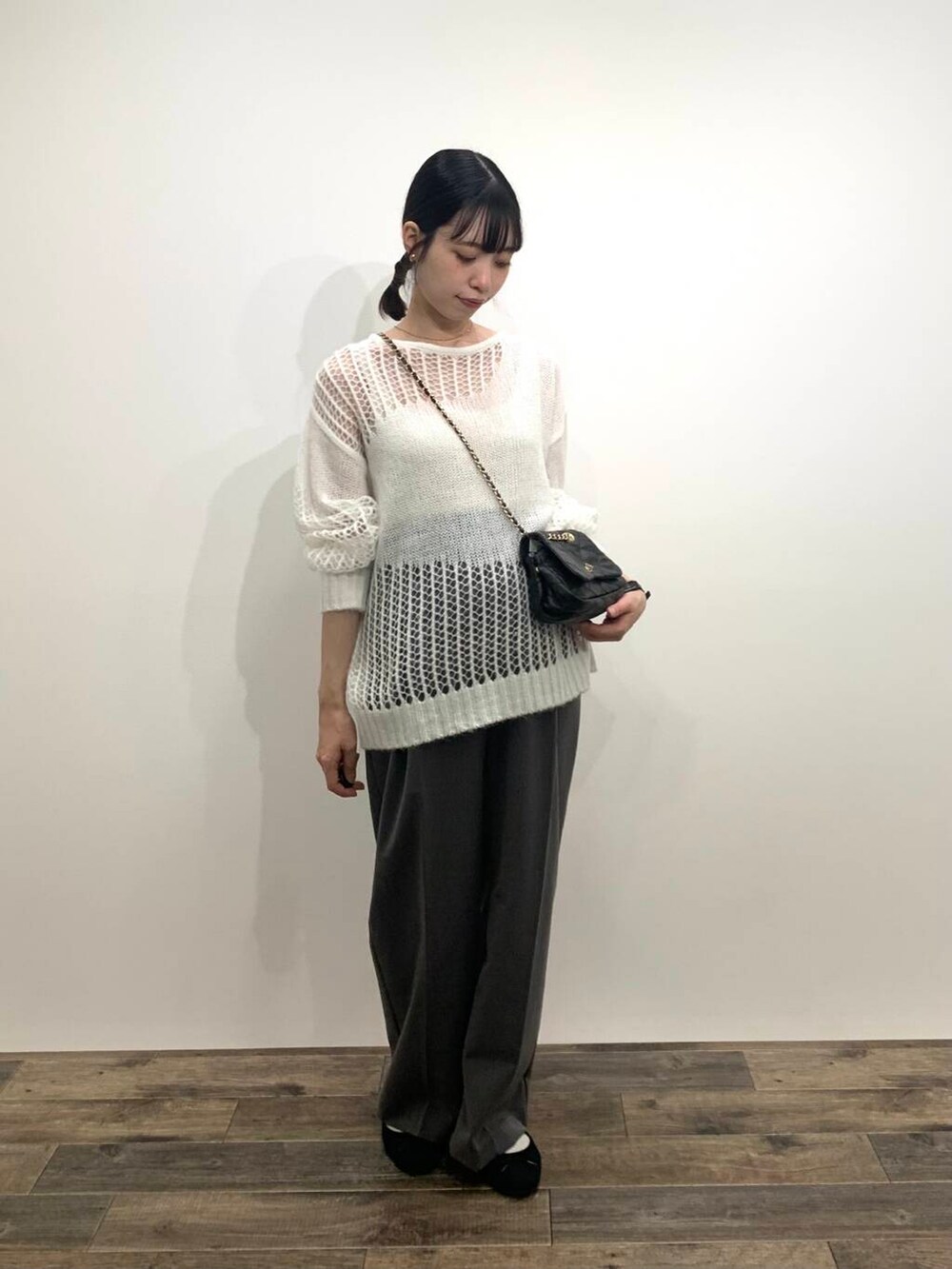 グレー系のその他パンツ、ブラック系のショルダーバッグ、ホワイト系のニット/セーターを着用したレディースの秋コーディネートの2枚目の写真