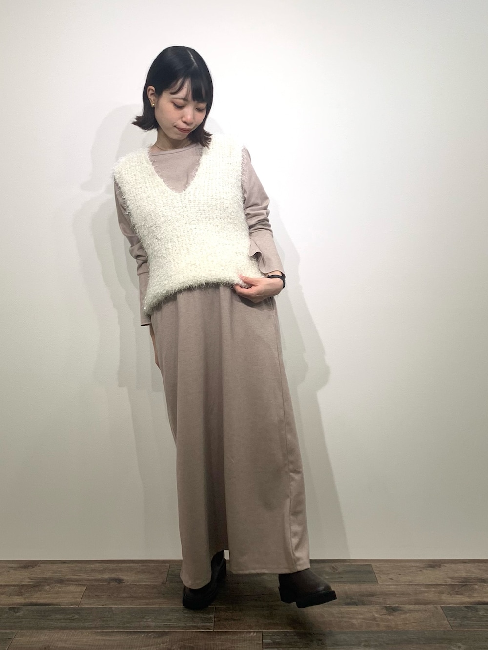 ホワイト系のベスト、ベージュ系のトートバッグ、ベージュ系のワンピースを着用したレディースの秋コーディネートの3枚目の写真