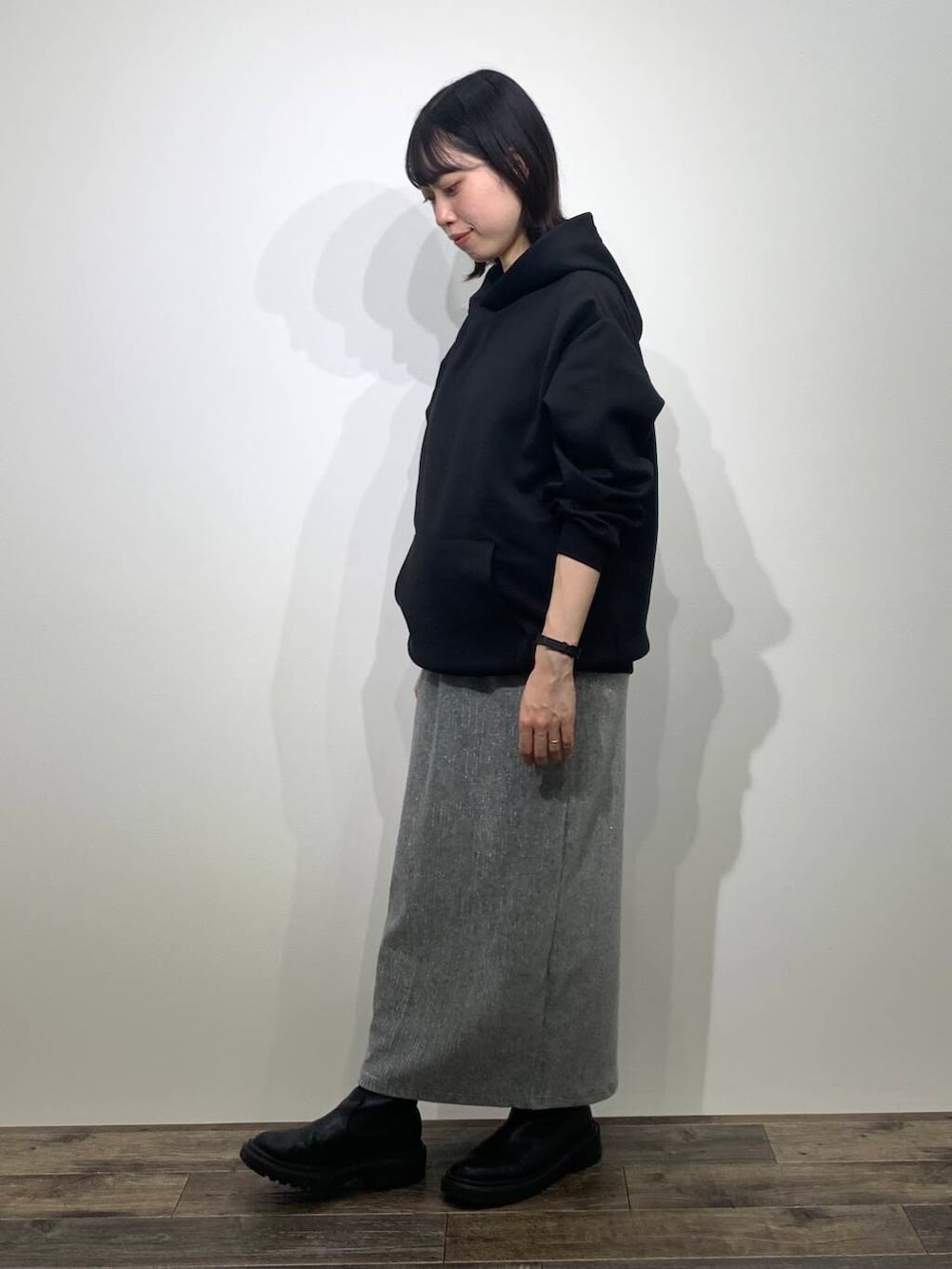 ブラック系のパーカー、グレー系のスカートを着用したレディースの秋コーディネートの3枚目の写真