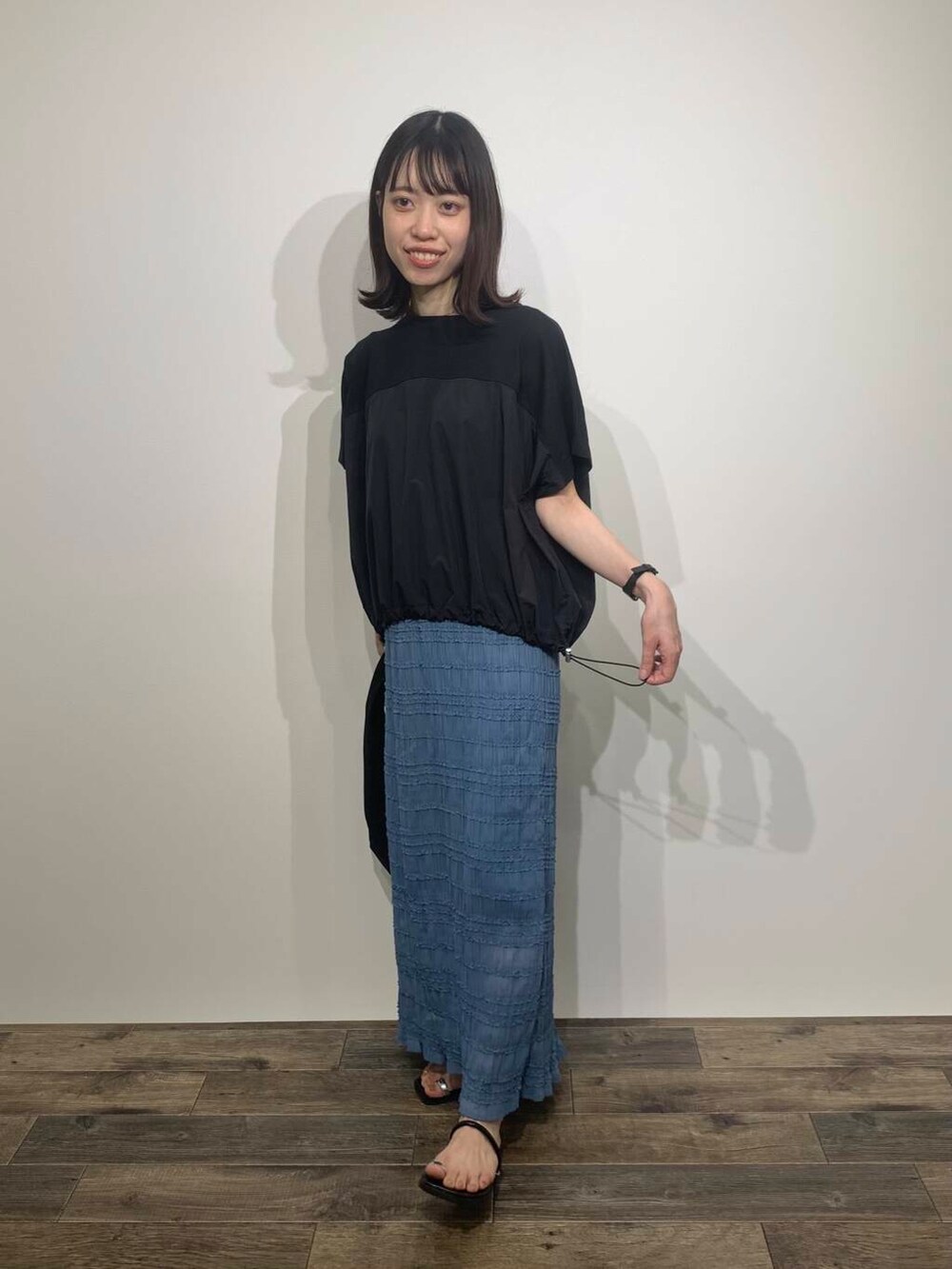 ブラック系のサンダル、ブルー系のスカート、ブラック系のトートバッグを着用したレディースの夏コーディネートの2枚目の写真