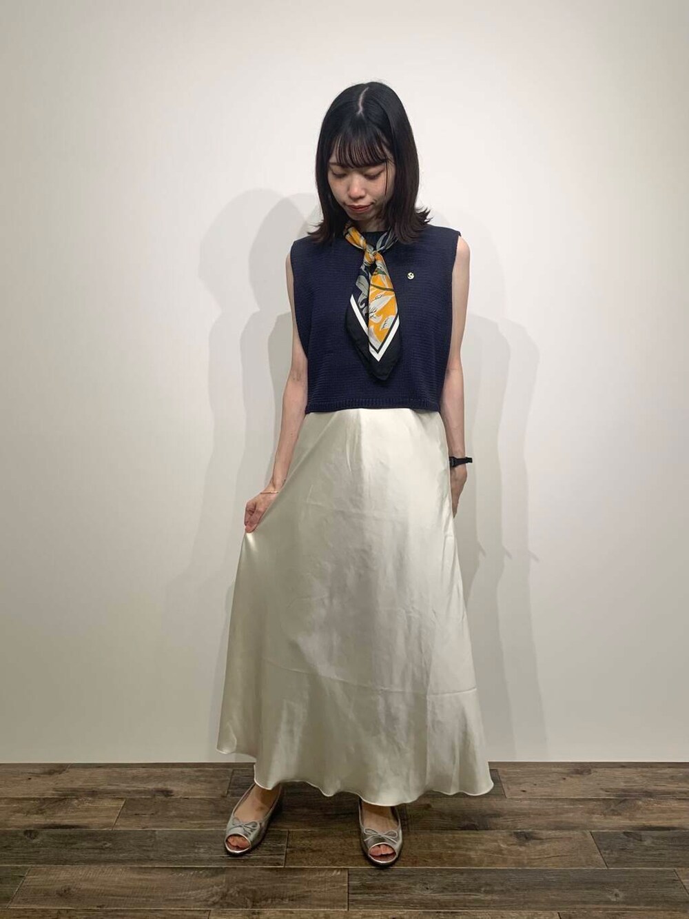 ホワイト系のトートバッグ、シルバー系のパンプス、ブルー系のニット/セーターを着用したレディースの夏コーディネートの4枚目の写真