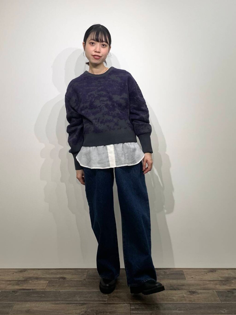 ブルー系のデニムパンツ、ブラック系のブーツ、ホワイト系のシャツ/ブラウスを着用したレディースの冬コーディネートの2枚目の写真