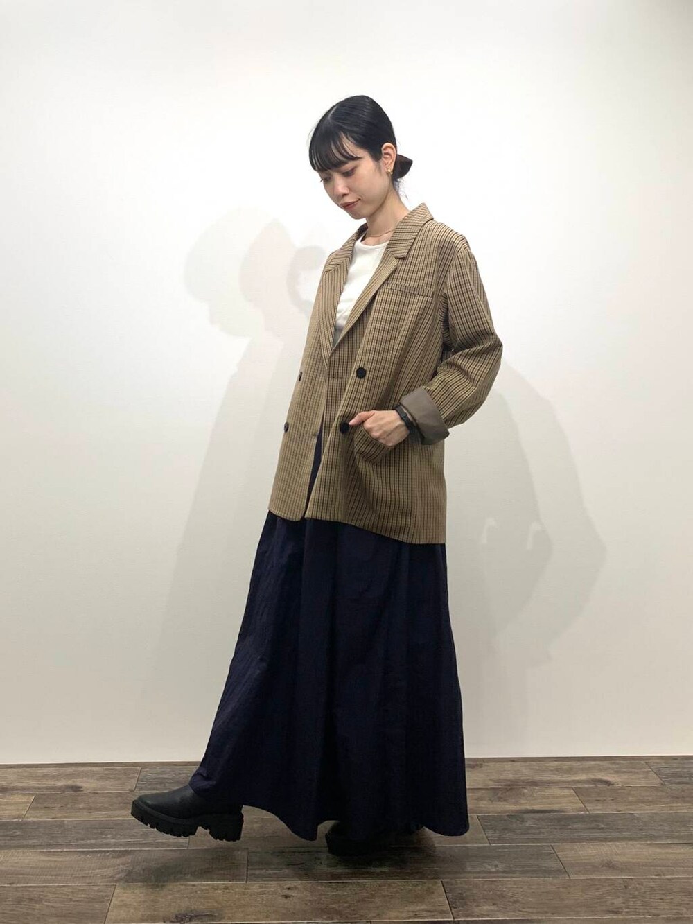 ブラック系のブーツ、ブルー系のスカート、ブラウン系のテーラードジャケットを着用したレディースの秋コーディネートの4枚目の写真