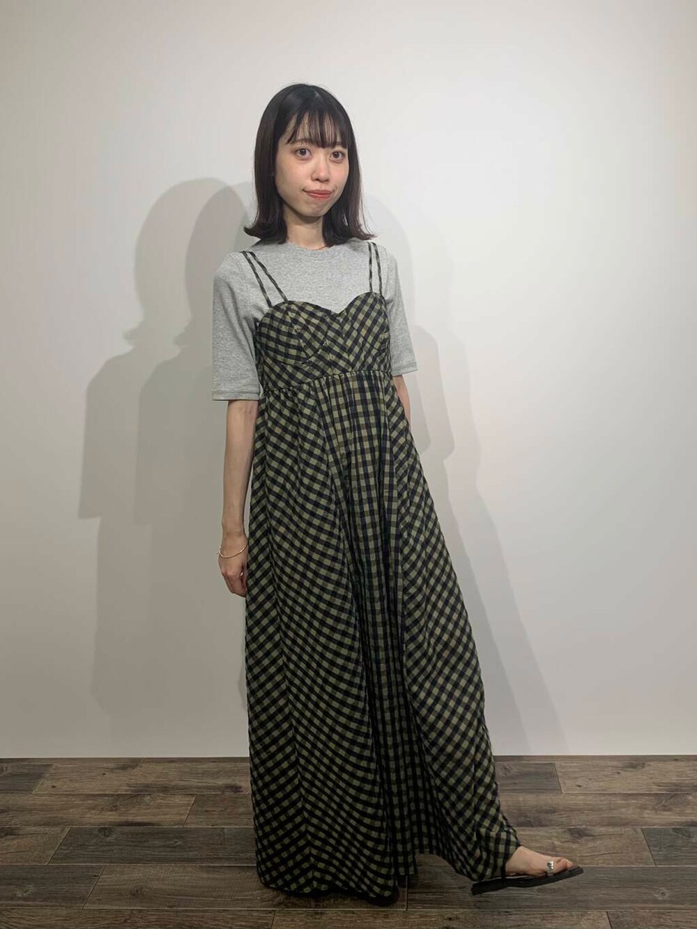 ブラック系のサンダル、グリーン系のワンピース、グレー系のTシャツ/カットソーを着用したレディースの夏コーディネートの2枚目の写真