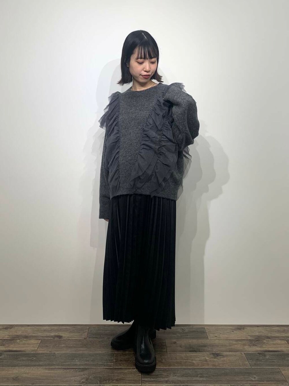 ブラック系のブーツ、グレー系のニット/セーター、ブラック系のスカートを着用したレディースの秋コーディネートの4枚目の写真