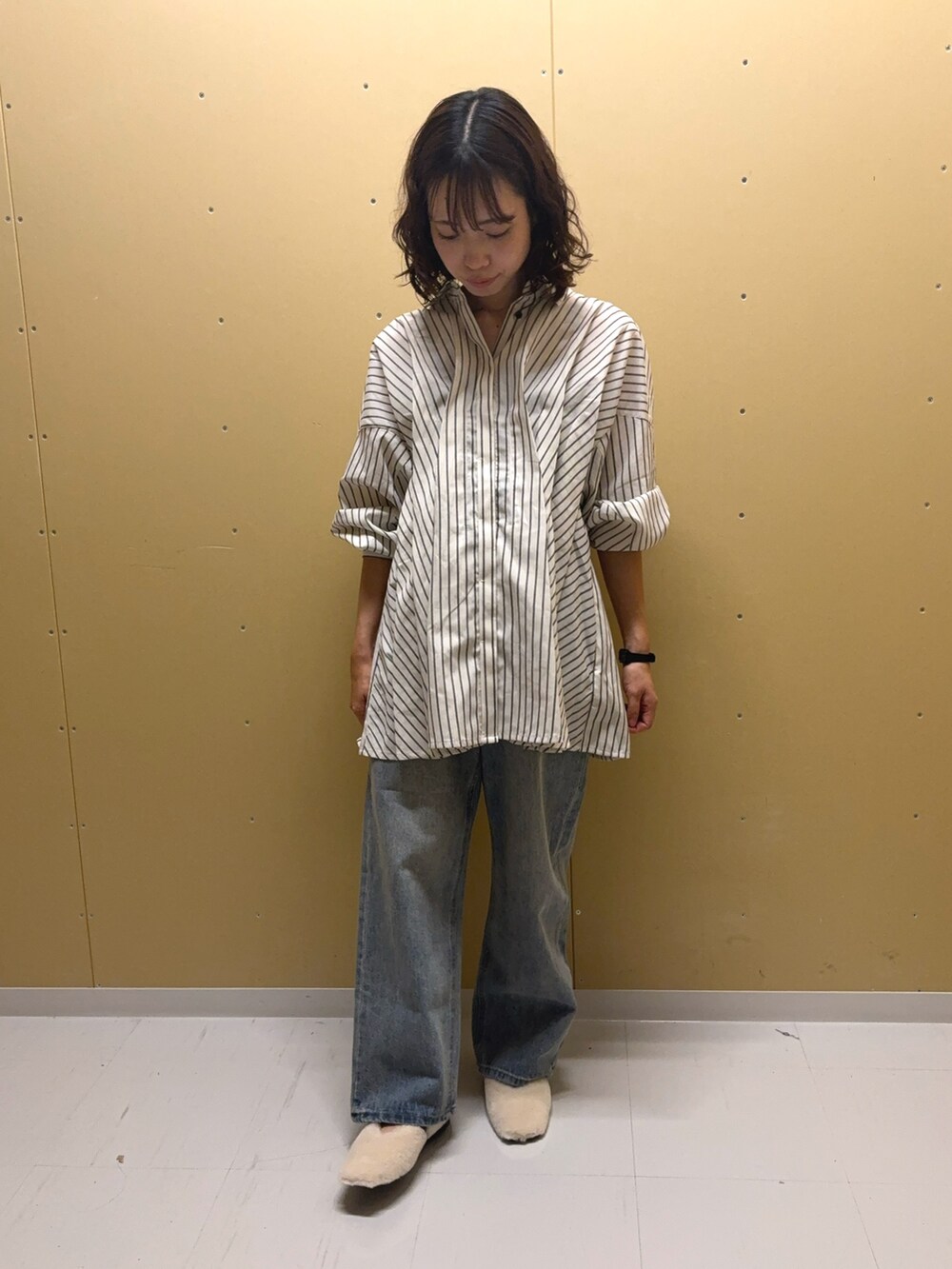 ホワイト系のチュニック、ブルー系のデニムパンツ、ホワイト系のその他シューズを着用したレディースの夏コーディネートの2枚目の写真