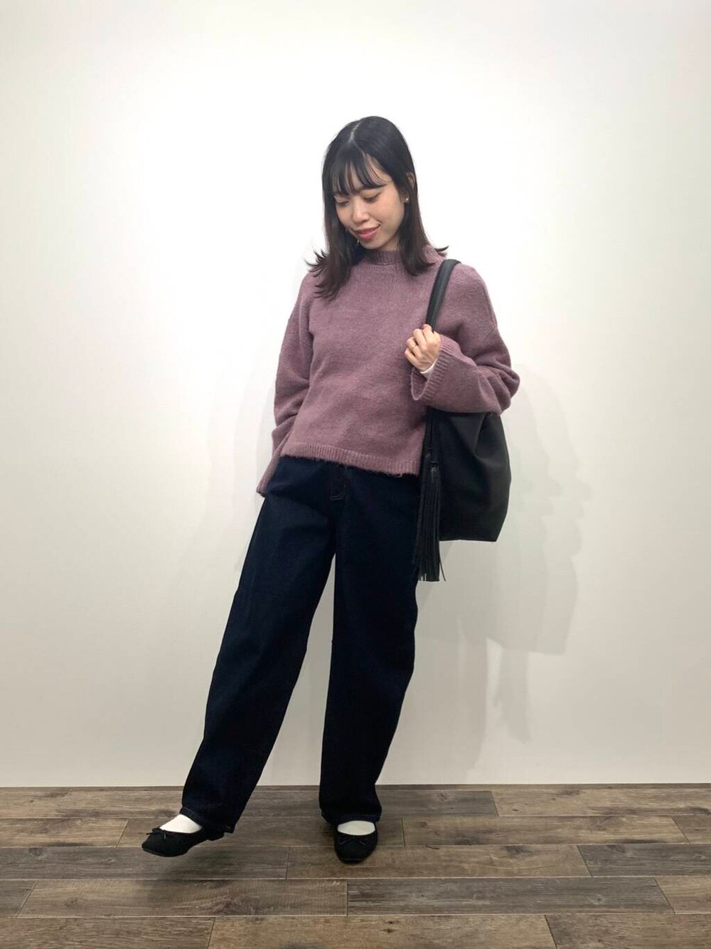 ブラック系のブーツ、ブルー系のデニムパンツ、ブラック系のトートバッグを着用したレディースの秋コーディネートの4枚目の写真