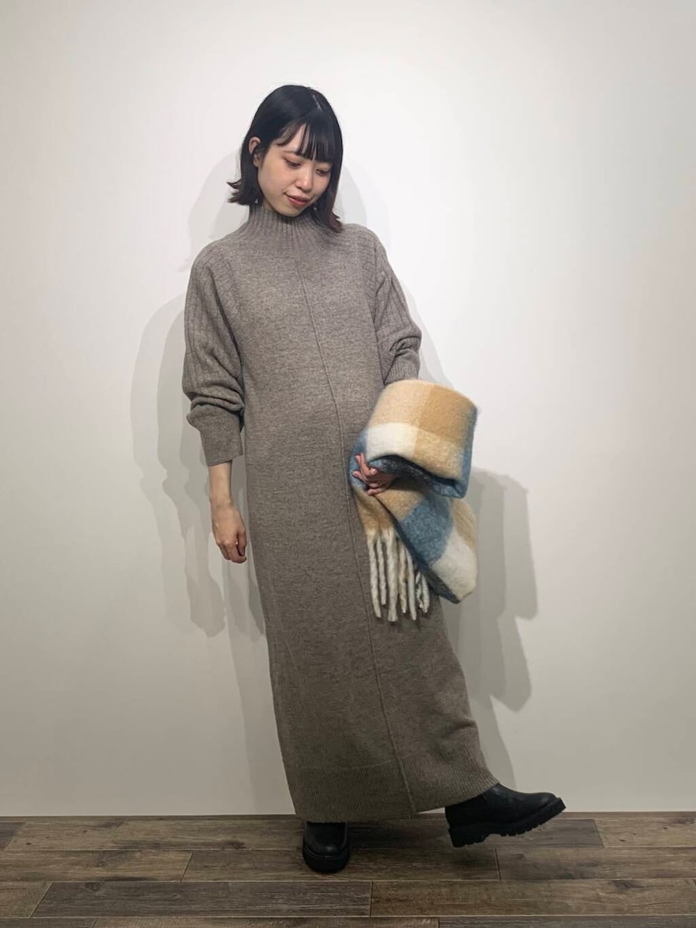 ブラック系のブーツ、ブラウン系のワンピース、ブルー系のマフラーを着用したレディースの秋コーディネートの5枚目の写真