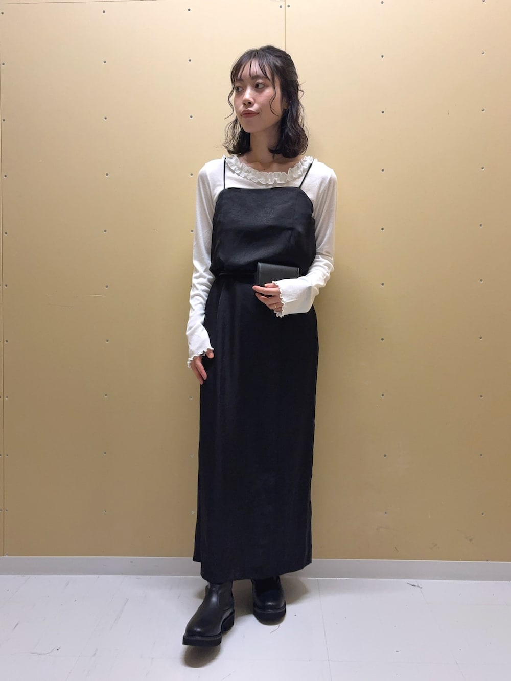 ブラック系のワンピース、ブラック系のブーツ、ホワイト系のTシャツ/カットソーを着用したレディースの秋コーディネートの4枚目の写真