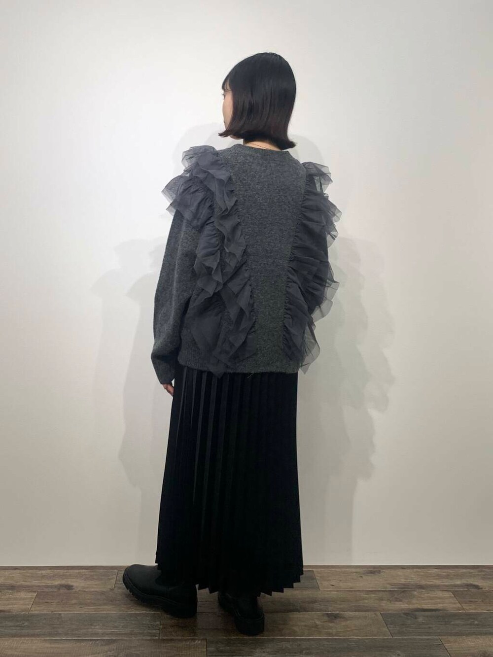 ブラック系のブーツ、グレー系のニット/セーター、ブラック系のスカートを着用したレディースの秋コーディネートの5枚目の写真