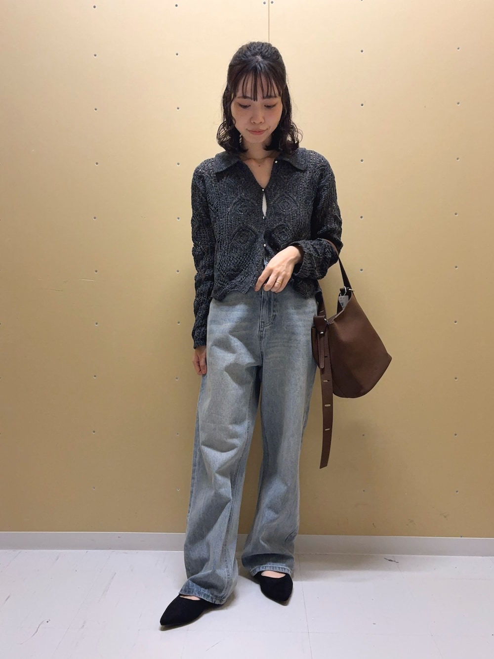 ブルー系のデニムパンツ、グレー系のカーディガン/ボレロ、ブラウン系のショルダーバッグを着用したレディースの秋コーディネートの3枚目の写真