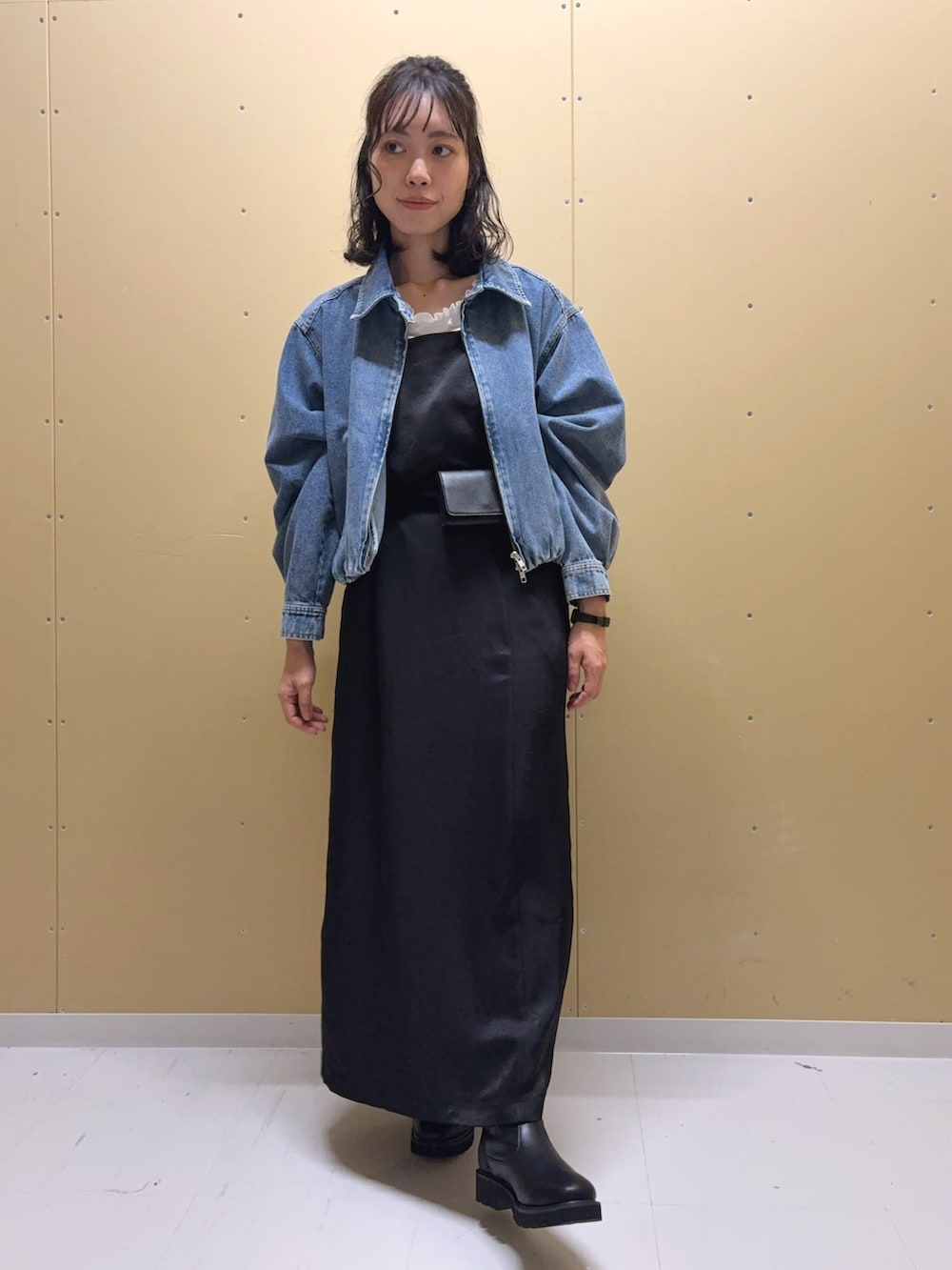 ブラック系のワンピース、ブラック系のブーツ、ホワイト系のTシャツ/カットソーを着用したレディースの秋コーディネートの2枚目の写真