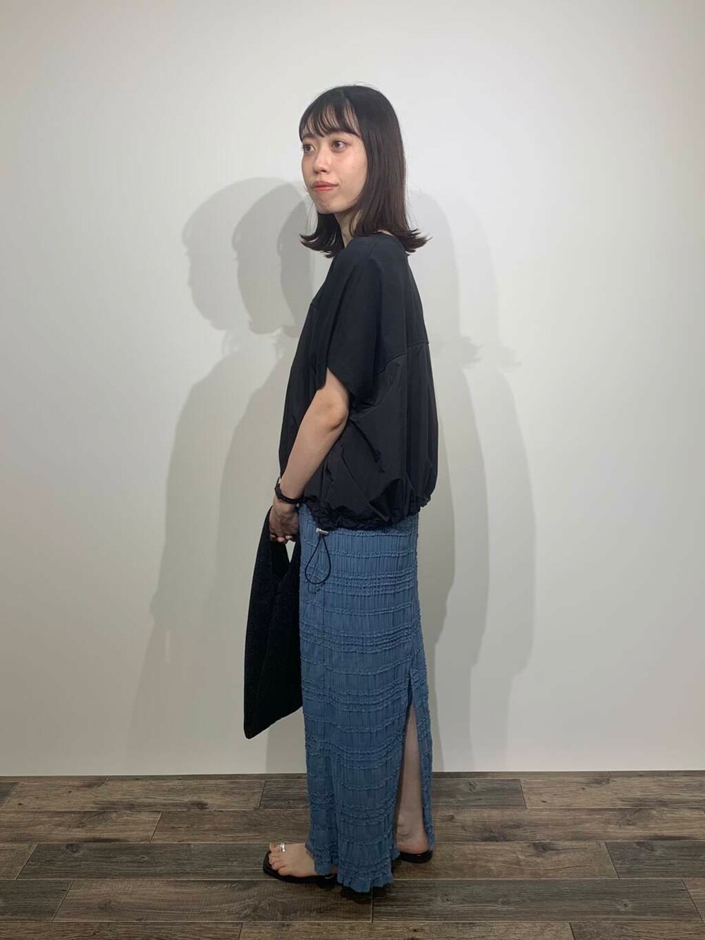 ブラック系のサンダル、ブルー系のスカート、ブラック系のトートバッグを着用したレディースの夏コーディネートの4枚目の写真