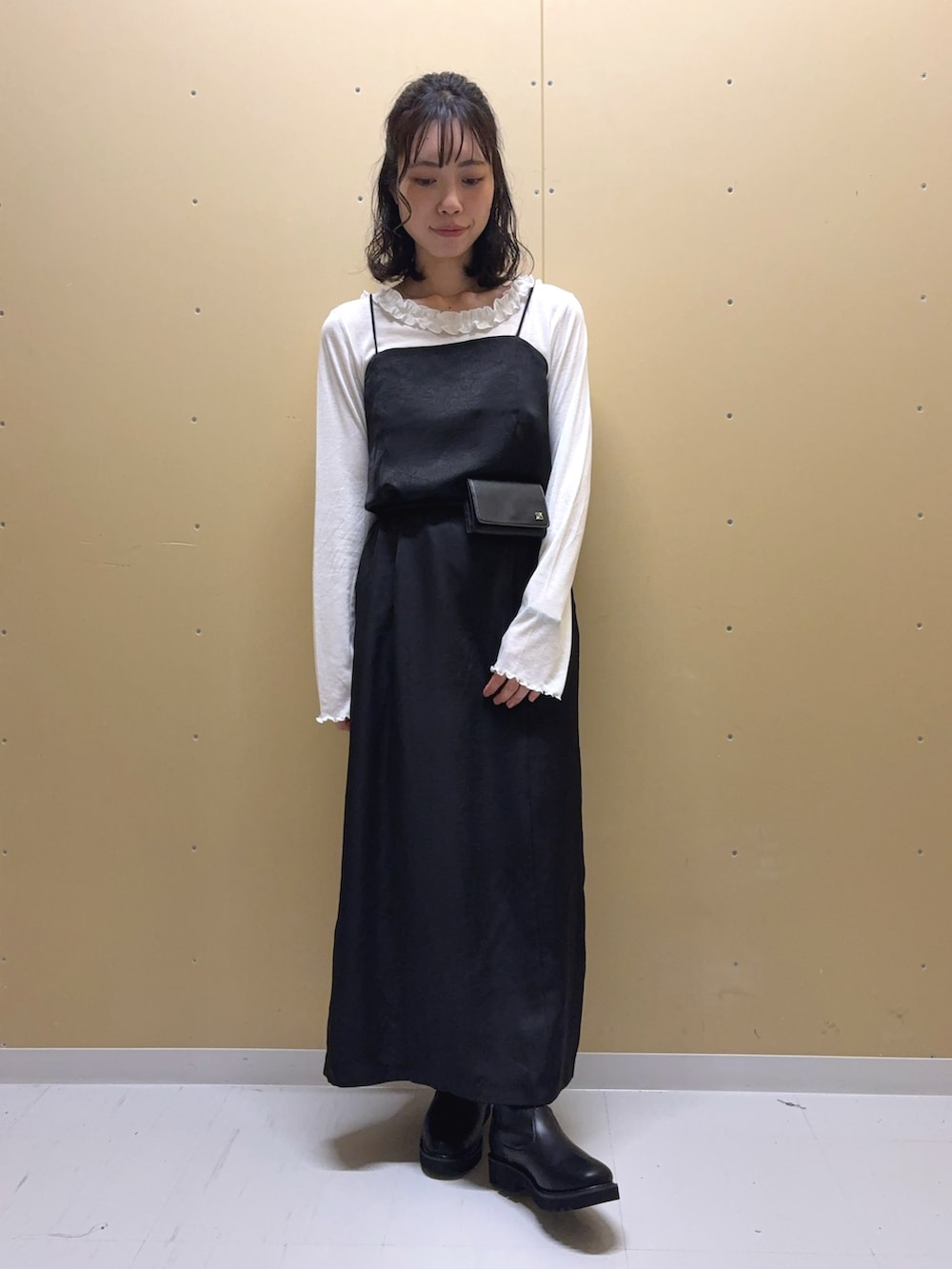 ブラック系のワンピース、ブラック系のブーツ、ホワイト系のTシャツ/カットソーを着用したレディースの秋コーディネートの3枚目の写真