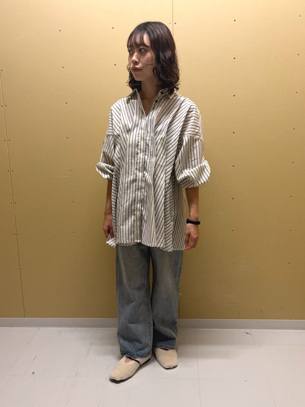 ホワイト系のチュニック、ブルー系のデニムパンツ、ホワイト系のその他シューズを着用したレディースの夏コーディネートの3枚目の写真