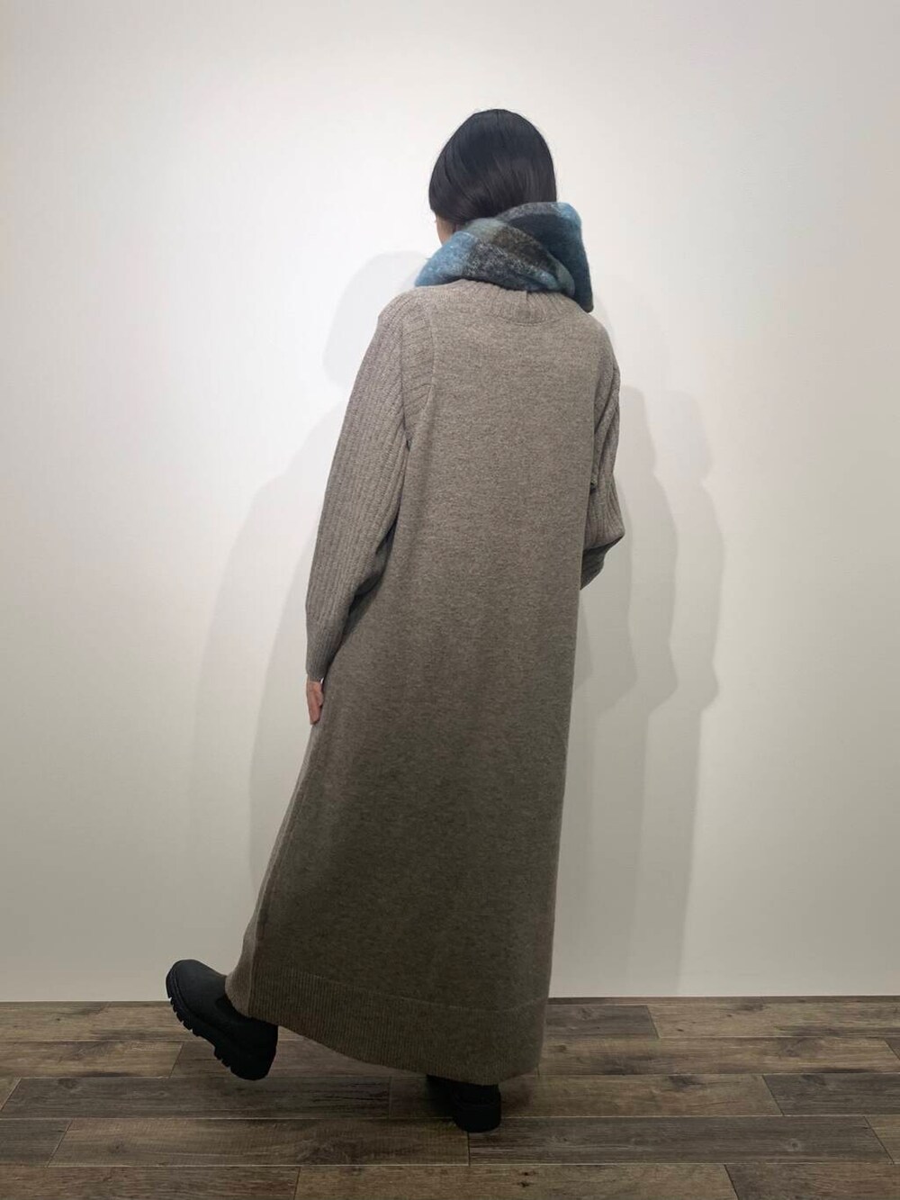 ブラック系のブーツ、ブラウン系のワンピース、ブルー系のマフラーを着用したレディースの秋コーディネートの3枚目の写真