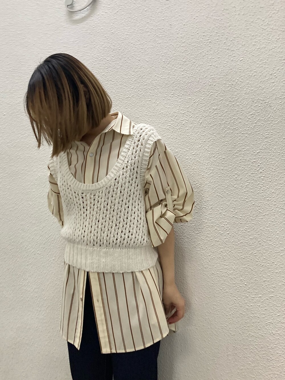 イエロー系のシャツ/ブラウス、ホワイト系のベスト、ブルー系のデニムパンツを着用したレディースの冬コーディネートの2枚目の写真