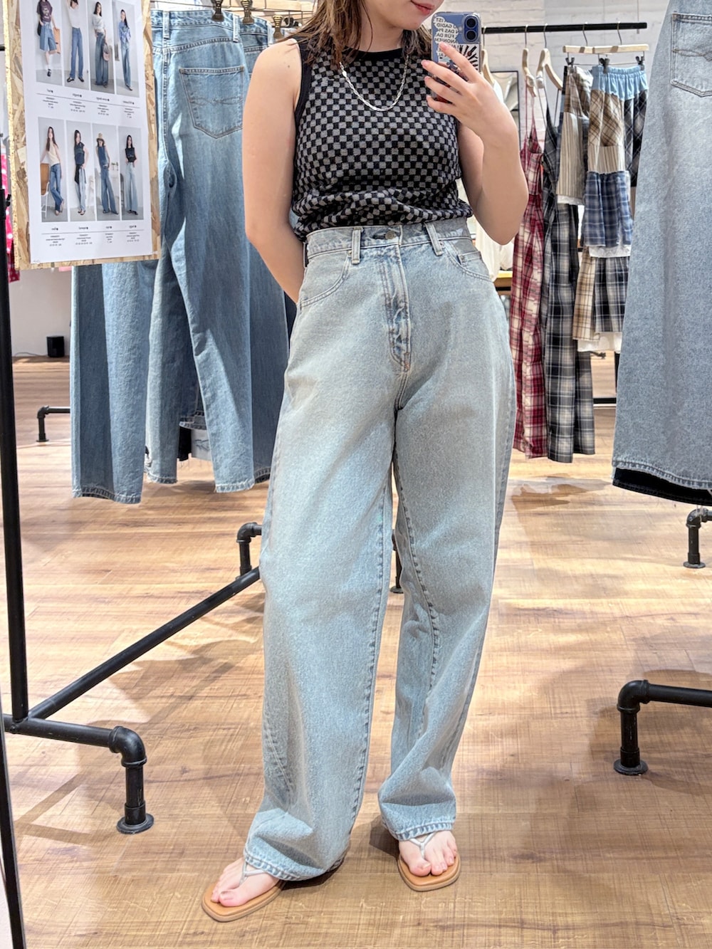 ブラック系のタンクトップ、ブルー系のデニムパンツ、ブラック系のハンチング/ベレー帽を着用したレディースの春コーディネートの2枚目の写真